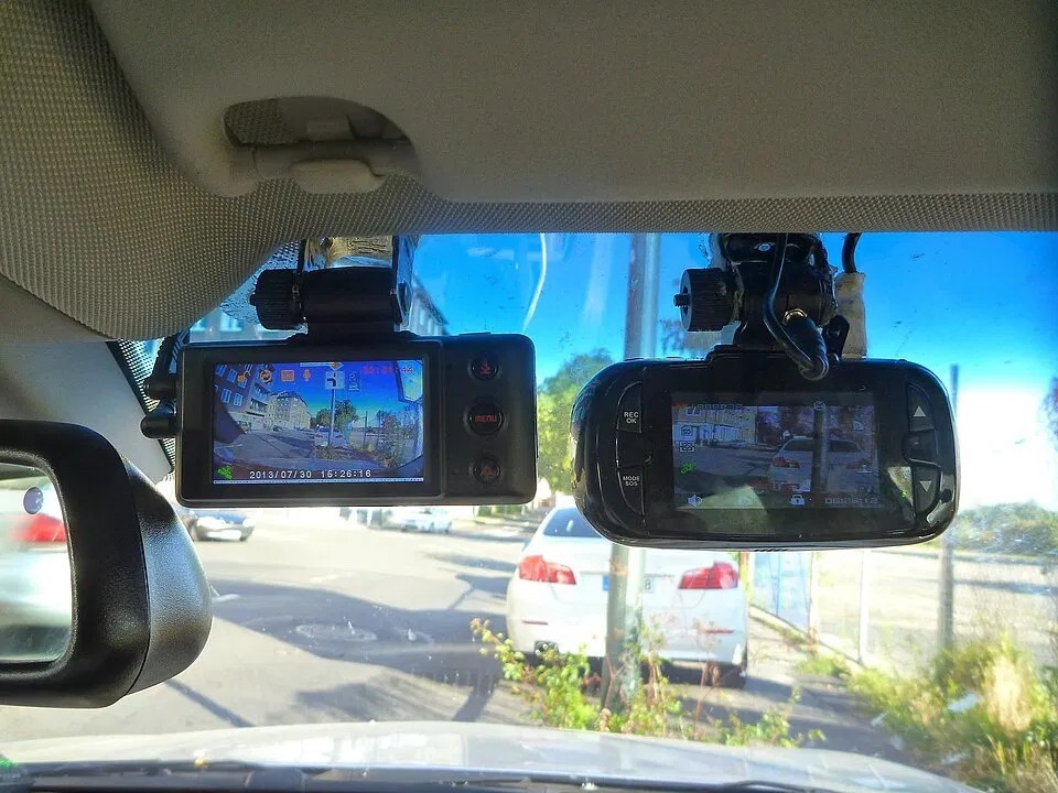 Two dashcams mounted on a car windshield