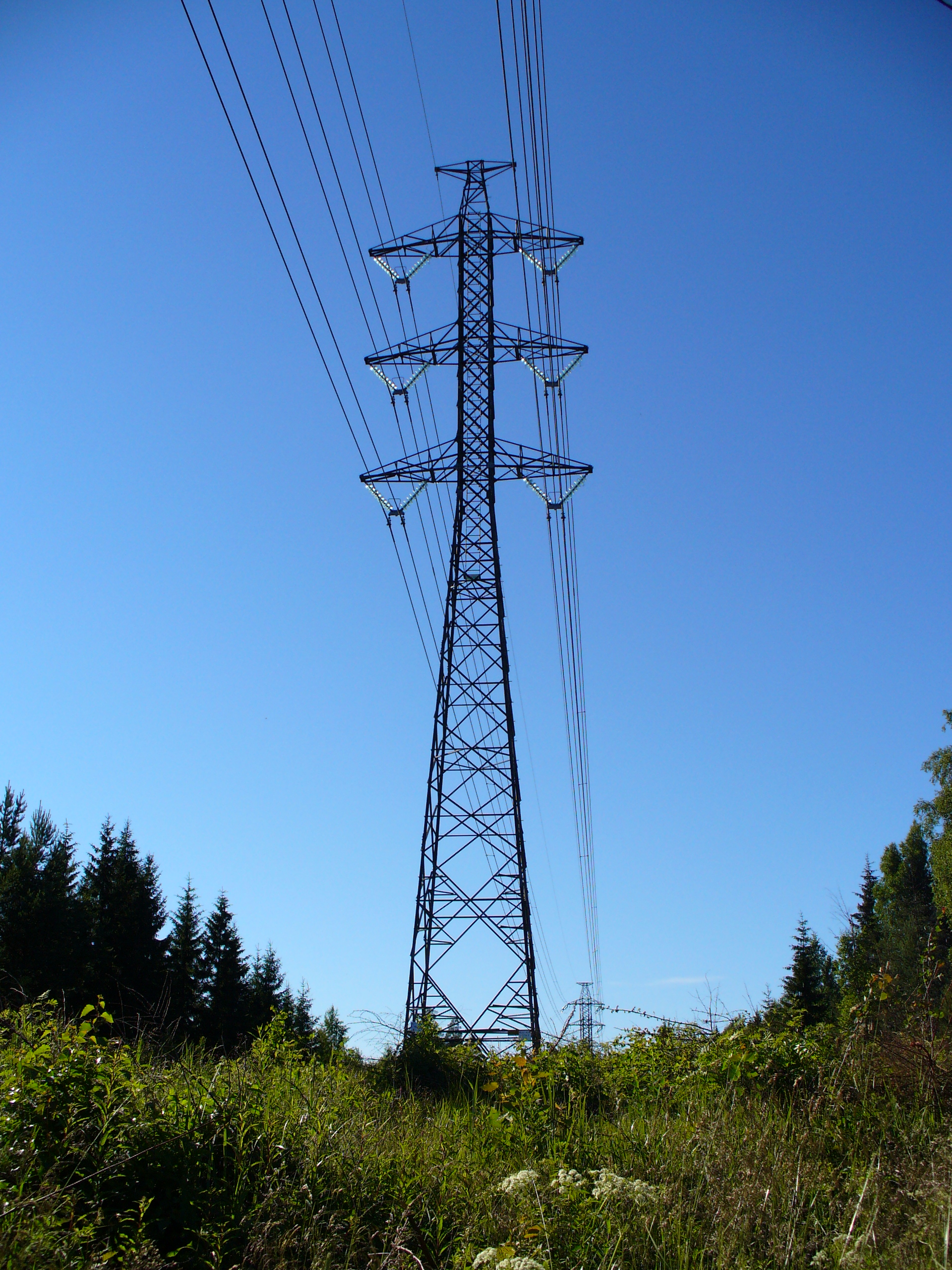 An electricity transmission tower against a clear sky