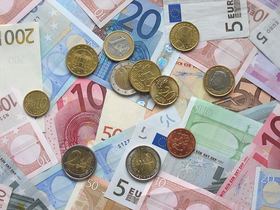 Euro banknotes and coins spread out together