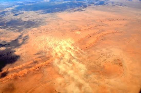 Aerial view of a dust plume blowing out over the ocean